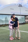 A mother and son stand on the practice field of the ASUI-Kibbie活动中心.